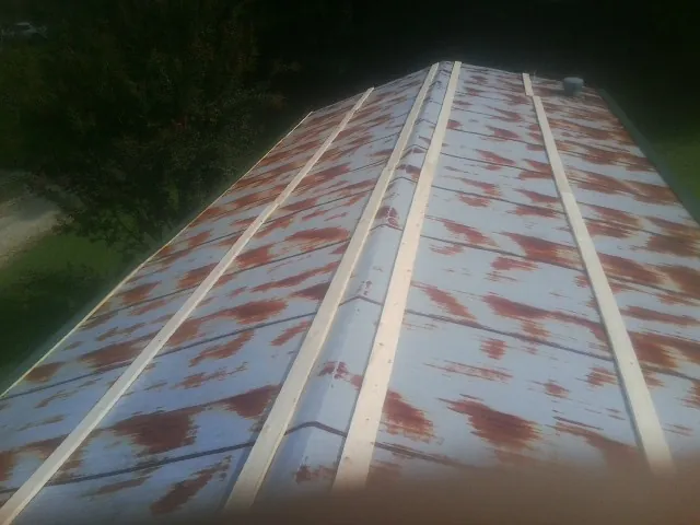 Rusted metal roof panels with new wood purlins before replacement — Storm Damage Roof Repair in Westborough by Roofing Brothers