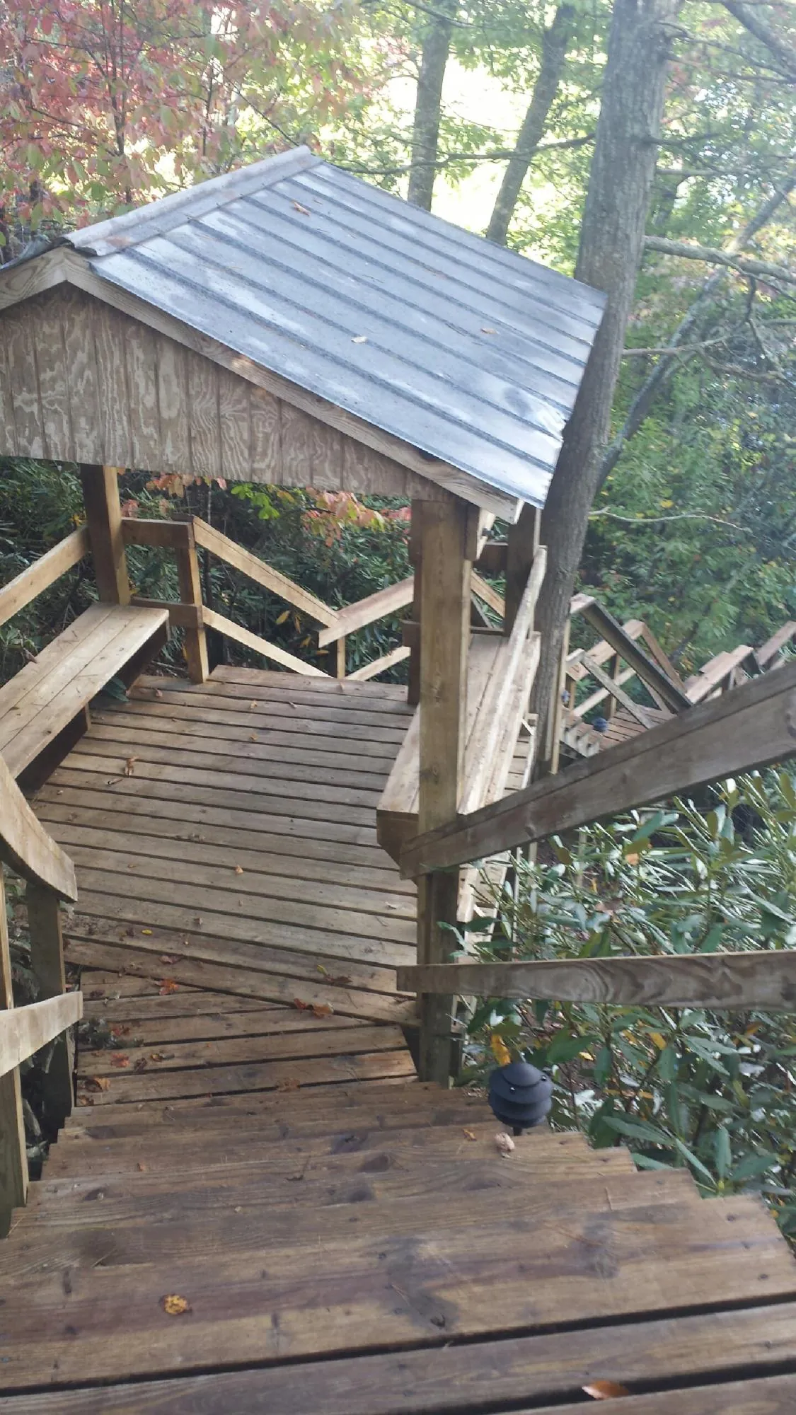 Metal roofed shelter over wooden steps on a wooded walkway — Skylight Repair & Installation work by our crew in Westborough