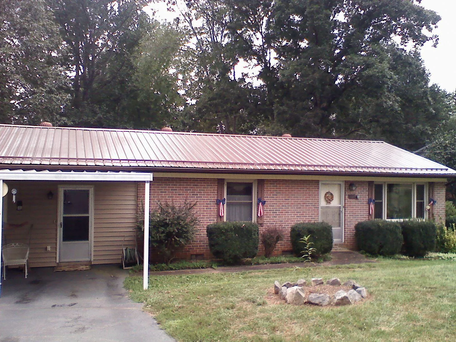 Bronze metal roof and carport on a brick ranch home — Roof Repair work by our crew in Westborough